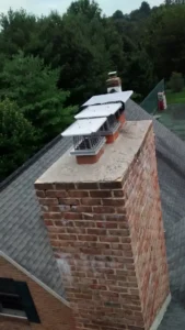 Old brick chimney with visible wear and multiple chimney caps.