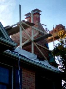 Red brick chimney with scaffolding for reconstruction.